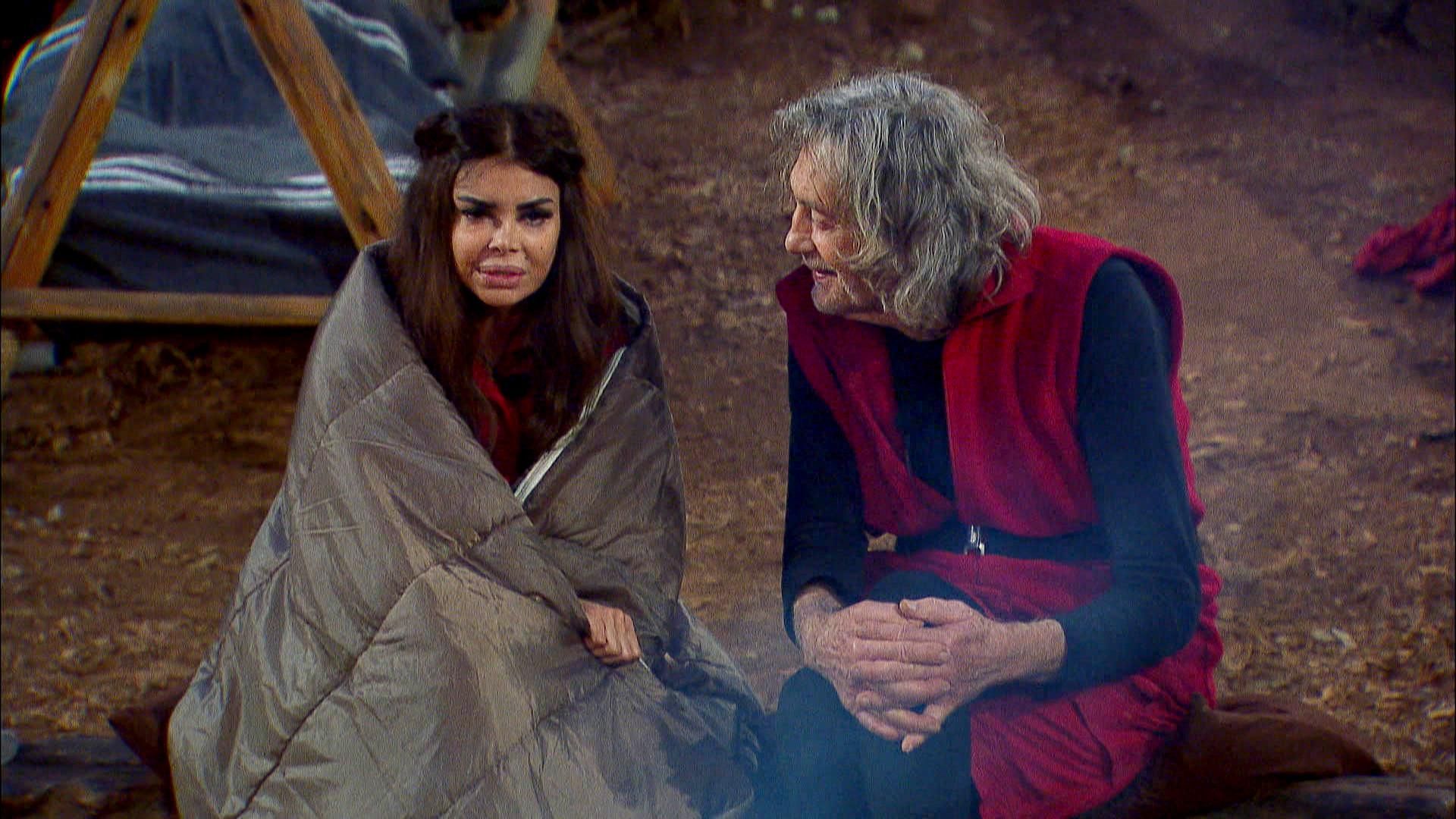 Kader Loth (links) sitzt am Lagerfeuer. 